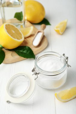 Kabartma tozu ve limon dilimleri beyaz ahşap masada.