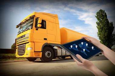 Lojistik konsept. Kamyona karşı ekranda dünya haritası olan tablet kullanan kadın