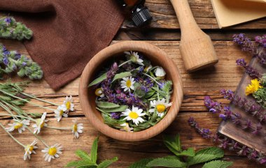 Havan ve farklı şifalı bitkilerle ahşap masada düz bir bileşim vardı.