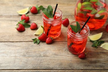 Çilek ve kireç ile ahşap masada taze içecek.