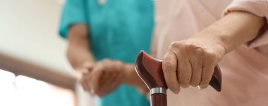 Huzurevinde yaşlı bir kadınla ilgilenen bir tıp çalışanı. Mesaj için yer var. Pankart tasarımı