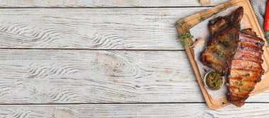 Lezzetli ızgara kaburga ve beyaz ahşap masa üzerinde yazı için yer olan servis panosu, üst manzara. Pankart tasarımı