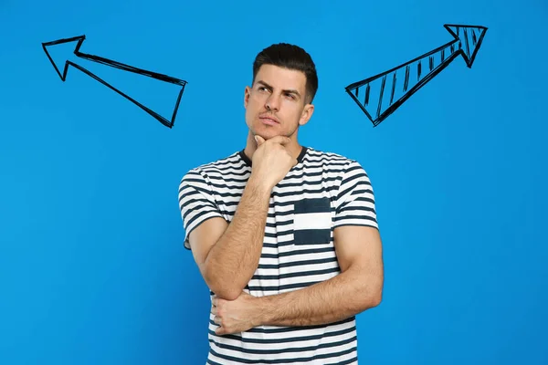 Pensive Man Standing Blue Wall Arrows — Stock Photo, Image