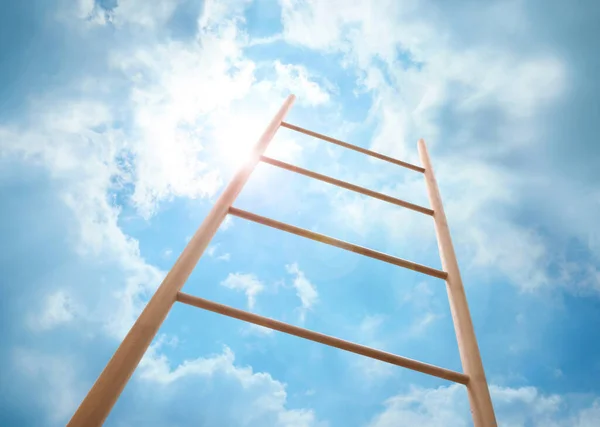 Wooden ladder against blue sky with clouds, low angle view