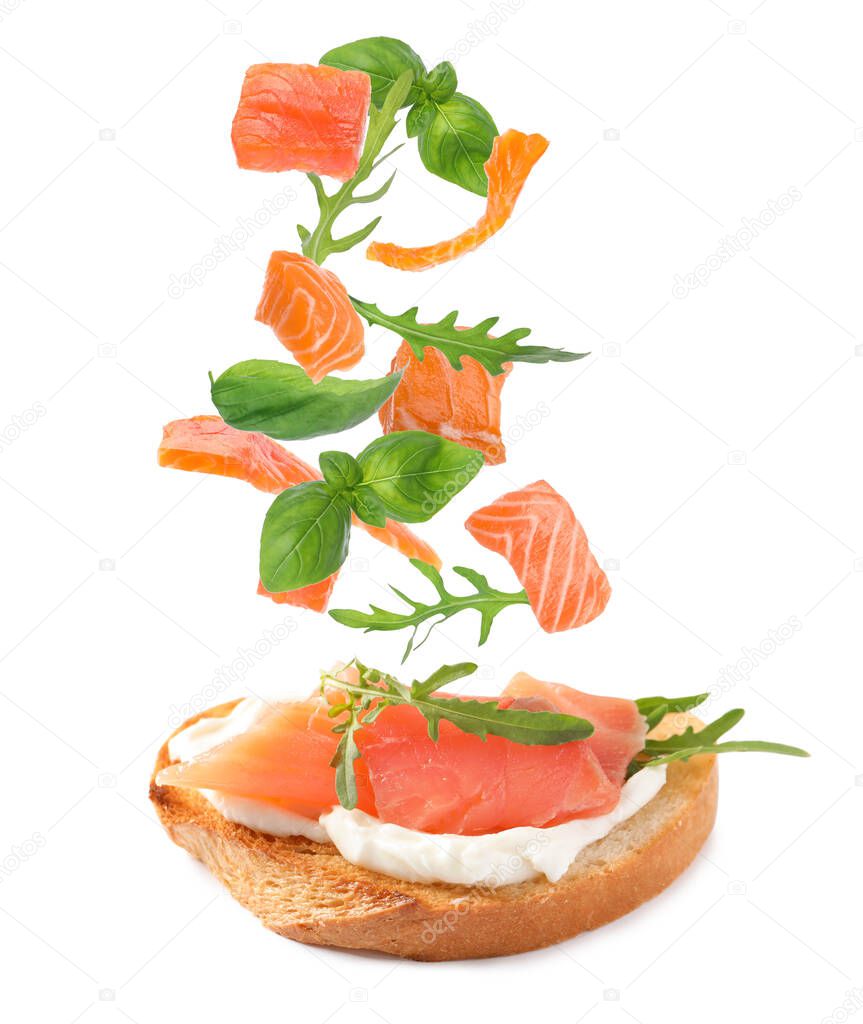 Tasty bruschetta with flying ingredients on white background