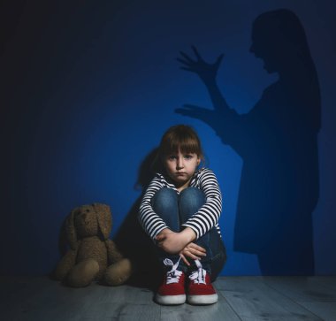 Çocuk istismarı. Anne kızına bağırıyor. Duvardaki kadının gölgesi