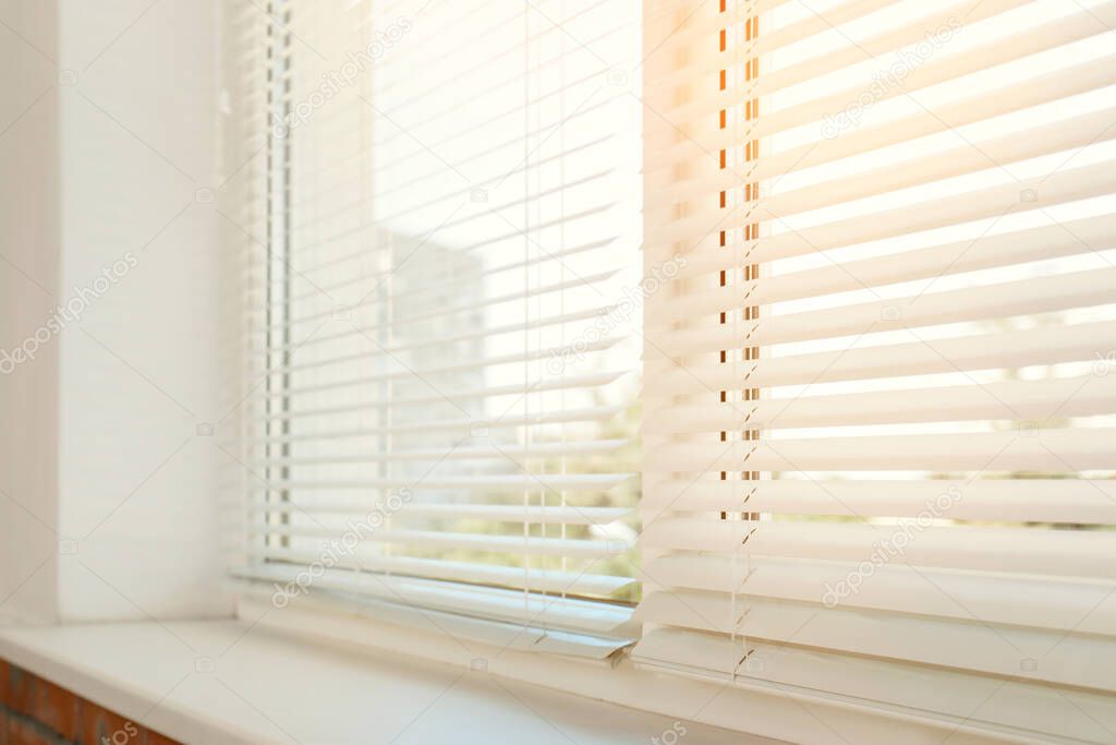 Beautiful view through window with blinds on sunny day, closeup