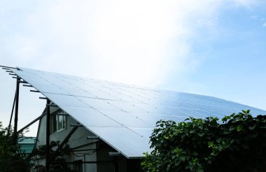 Çatıda güneş panelleri olan bir ev. Alternatif enerji kaynağı