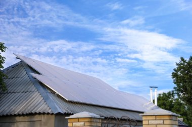 Çatıda güneş panelleri olan bir ev. Alternatif enerji kaynağı