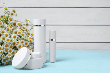 Papatya çiçekleri ve kozmetik ürünleriyle ahşap masa üzerinde kompozisyon, metin için alan