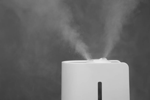 Modern air humidifier on grey background, closeup. Space for text