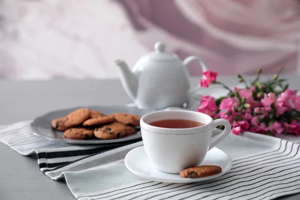 一杯香茶和灰色桌子上美味的饼干 — 图库照片