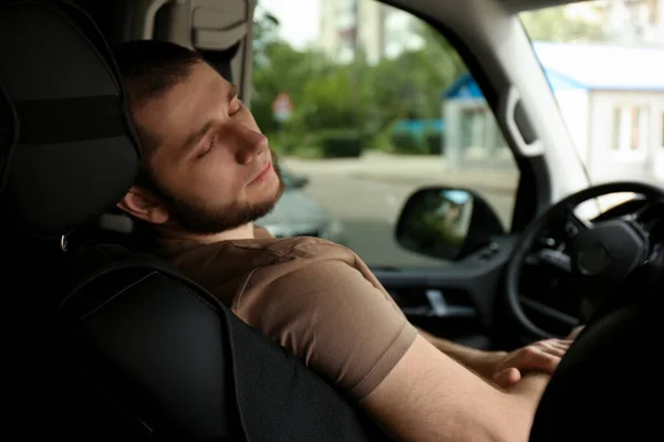 疲れた男は彼の近代的な車の中で寝て — ストック写真