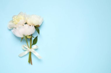 Açık mavi arka planda güzel bir buket taze şakayık, düz. Metin için boşluk
