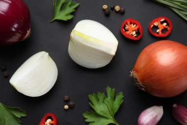 Siyah zemin üzerinde soğan ve baharatlarla düzleştirilmiş bileşim