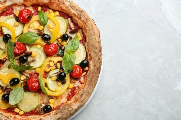 Tasty vegetable pizza on light grey table, top view. Space for text