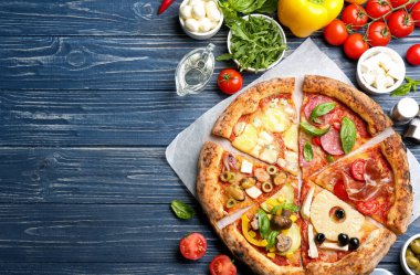 Mavi ahşap masa üzerinde farklı pizza dilimleri, düz yatıyordu. Metin için boşluk