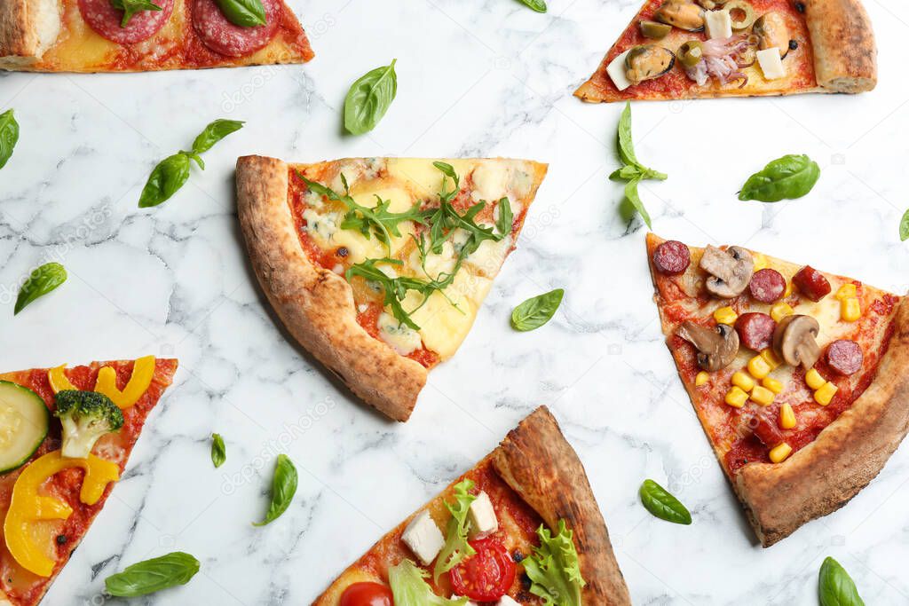 Flat lay composition with slices of different delicious pizzas on white marble table