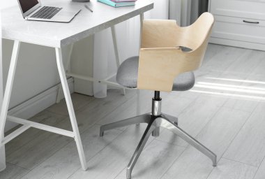 Ofis sandalyesi ve modern masası olan rahat bir iş yeri.