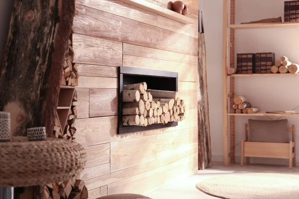 Decorative fireplace with stacked wood in cozy living room interior