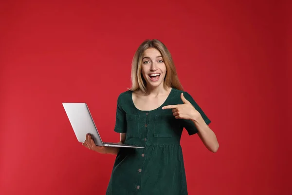 Kırmızı Arka Planda Modern Dizüstü Bilgisayarlı Duygusal Kadın Portresi — Stok fotoğraf