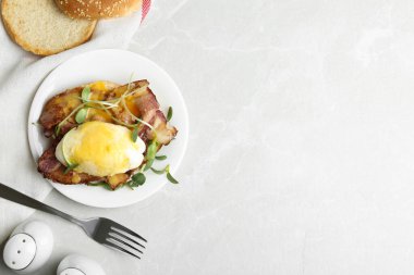 Benedict yumurtası açık gri mermer masada servis ediliyor. Metin için boşluk