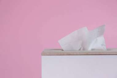 Pembe arka planda kağıt mendilli tutucu, yakın plan. Metin için boşluk