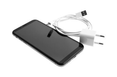 Akıllı telefon ve USB şarj cihazı beyazda izole edildi. Modern teknoloji