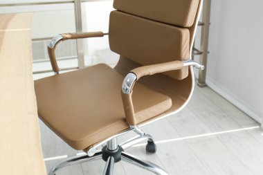 Ofis sandalyesi ve ahşap masası olan rahat bir iş yeri, yakın plan.