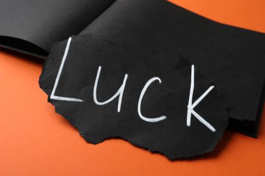 Kağıt ve not defteri kelime ile şans turuncu arka planda, yakın plan