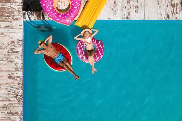 Glückliches Paar Mit Aufblasbaren Ringen Schwimmbad Von Oben Gesehen Sommerferien — Stockfoto