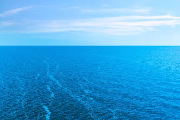 雲と青い空の下で美しい波打つ海 — ストック写真