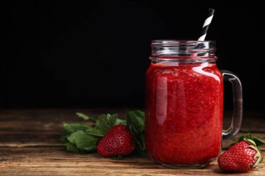 Lezzetli çilekli smoothie ve ahşap masada nane.