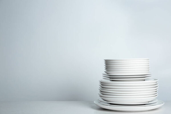 Stack of clean plates on white background