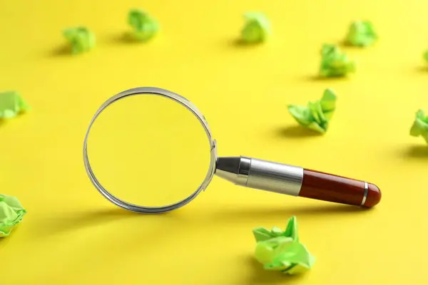 Magnifier Glass Green Crumpled Paper Sheets Yellow Background Closeup Find — Stock Photo, Image