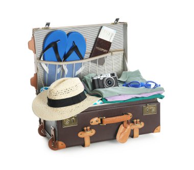 Yaz tatili için hazırlanmış giysilerle birlikte beyaz üzerine izole edilmiş açık klasik valiz.