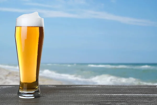 Koud Bier Houten Bureau Tegen Wazige Zee Ruimte Voor Tekst — Stockfoto