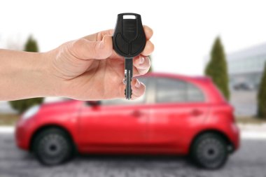Araba almak. Bulanık otomobilin anahtarı kadının elinde, yakın plan.