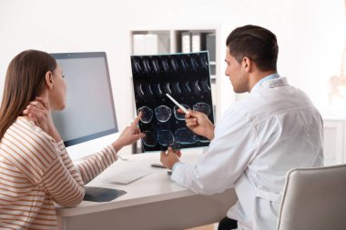 Ortopedist, klinikteki hastaya röntgen filmi gösteriyor.