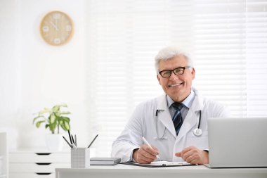 İş yerinde beyaz önlüklü kıdemli doktorun portresi.