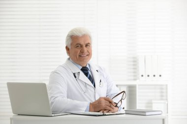İş yerinde beyaz önlüklü kıdemli doktorun portresi.