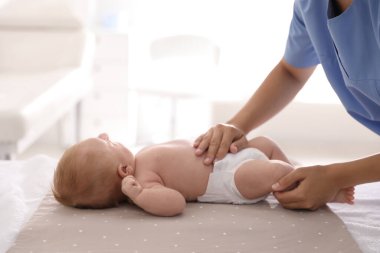 Doktor, klinikte şirin bebeği muayene ediyor, yakın plan. Sağlık hizmetleri