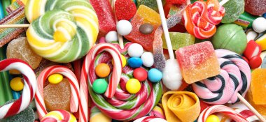 Arka plan olarak pek çok lezzetli şekerler, üst görünüm. Pankart tasarımı 