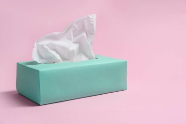 Pembe arka planda kağıt mendil kutusu