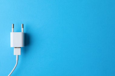Açık mavi arkaplanda USB şarj cihazı, metin için üst görünüm boşluğu