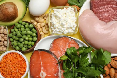Sarı zemin üzerinde protein açısından zengin farklı ürünler.