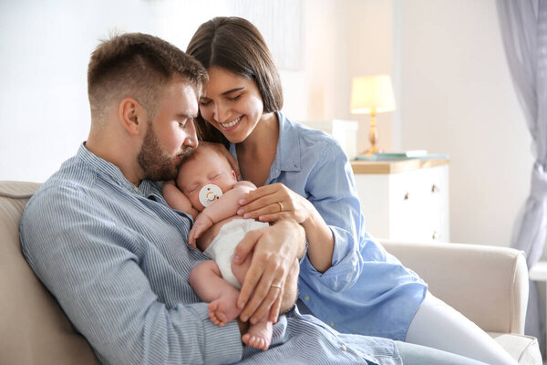 Happy couple with their newborn baby at home
