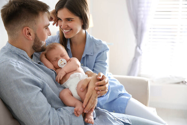 Happy couple with their newborn baby at home