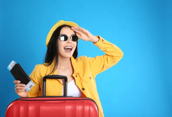 青い背景に夏の旅行のためのパスポートのスーツケースとチケットを持つ美しい女性 休暇旅行 — ストック写真