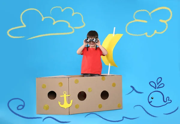 Lindo Niño Pequeño Jugando Barco Cartón Sobre Fondo Azul Claro — Foto de Stock